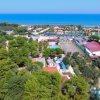 Vista panoramica di un'area con alberi e mare sullo sfondo.