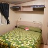 Una camera da letto con letto matrimoniale e copriletto verde.