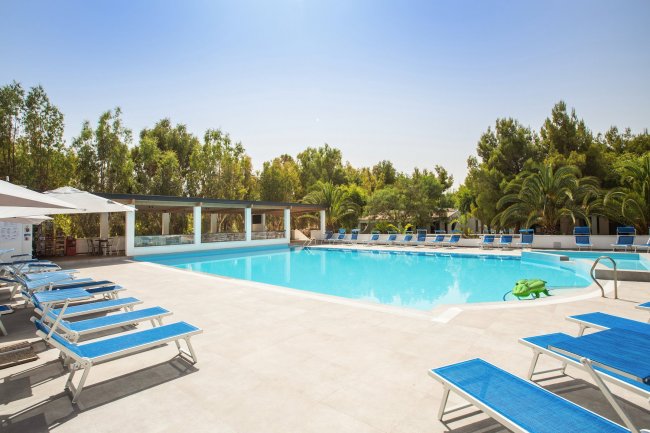 Piscina azzurra circondata da lettini.