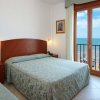 Camera d'hotel con due letti, balcone e vista sul mare.