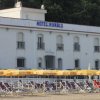 Edificio bianco dell'hotel Riva Blu con ombrelloni gialli all'esterno.