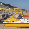 Spiaggia con sdraio e ombrelloni gialli sotto un cielo sereno.