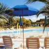 Piscina con ombrelloni blu e lettini.