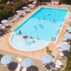 Piscina con lettini e ombrelloni a righe.